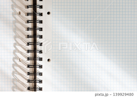 Blank white squared notebook page with metallic spiral binding background with lights and shadows. template mockup Blank white squared notebook page with metallic spiral binding background with lights and shadows. template mockup 139929480