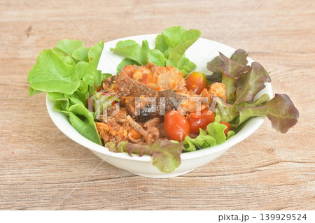 spicy fried roasted duck meat with tomato in curry and red oak salad on bowl spicy fried roasted duck meat with tomato in curry and red oak salad on bowl 139929524