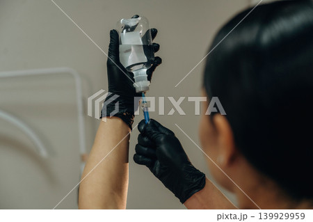 Close-up of a cosmetologist holding a syringe and serum for a facial skincare procedure in a beauty clinic 139929959
