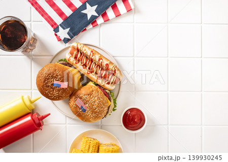 Burgers and hot dog with American flags on white background for Fourth of July Burgers and hot dog with American flags on white background for Fourth of July 139930245