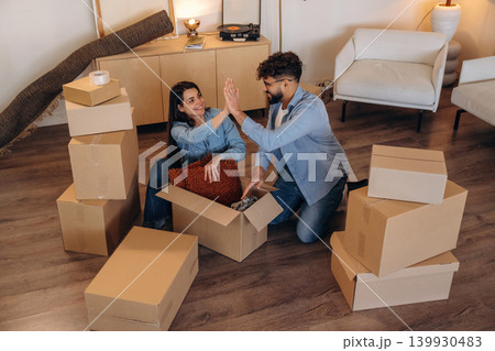 High five hands gesture, successful. Playful couple enjoying time together while moving into a new home High five hands gesture, successful. Playful couple enjoying time together while moving into a new home 139930483
