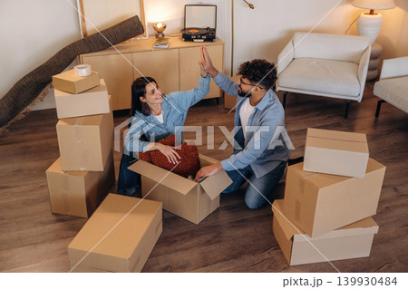 High five hands gesture, successful. Playful couple enjoying time together while moving into a new home High five hands gesture, successful. Playful couple enjoying time together while moving into a new home 139930484