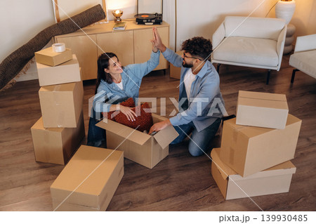 High five hands gesture, successful. Playful couple enjoying time together while moving into a new home High five hands gesture, successful. Playful couple enjoying time together while moving into a new home 139930485