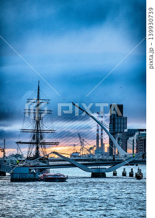 Samuel Beckett Bridge and Jeanie Johnston Famine Ship in Dublin Ireland at Sunrise with River Liffey Samuel Beckett Bridge and Jeanie Johnston Famine Ship in Dublin Ireland at Sunrise with River Liffey 139930739