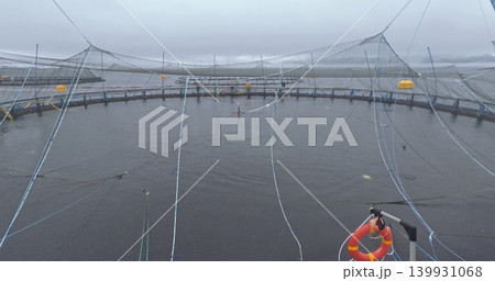 Large fish farm in the water with nets under cloudy sky as background 139931068