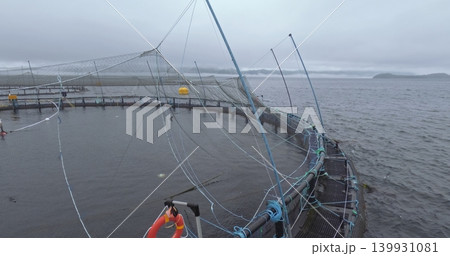 Large fish farm in the water with nets under cloudy sky as background 139931081