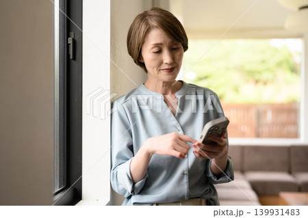 窓辺でスマホを操作する女性 窓辺でスマホを操作する女性 139931483