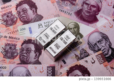 A silver bar, white metal against a backdrop of Mexican money, concept for the sales market A silver bar, white metal against a backdrop of Mexican money, concept for the sales market 139931666