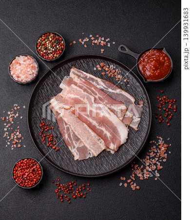 Raw fresh bacon slices with layers of meat or prosciutto with salt and spices. Raw bacon Raw fresh bacon slices with layers of meat or prosciutto with salt and spices. Raw bacon 139931683