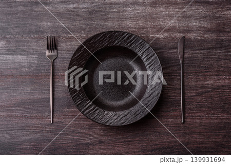 An empty ceramic round plate, kitchen utensils for a dinner table. An empty plate 139931694