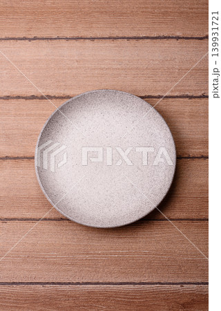 An empty ceramic round plate, kitchen utensils for a dinner table. An empty plate An empty ceramic round plate, kitchen utensils for a dinner table. An empty plate 139931721