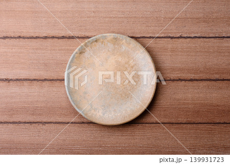 An empty ceramic round plate, kitchen utensils for a dinner table. An empty plate An empty ceramic round plate, kitchen utensils for a dinner table. An empty plate 139931723