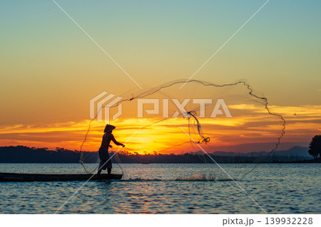 Traditional Fisherman Working on Wooden Boat at Sunset 139932228