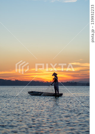 Traditional Fisherman Working on Wooden Boat at Sunset 139932233