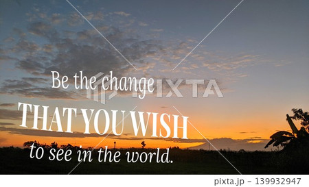 An inspiring quote, "Be the change THAT YOU WISH to see in the world," is placed over a stunning sunrise landscape with vibrant orange and purple colors and silhouetted trees and mountains. An inspiring quote, "Be the change THAT YOU WISH to see in the world," is placed over a stunning sunrise landscape with vibrant orange and purple colors and silhouetted trees and mountains. 139932947