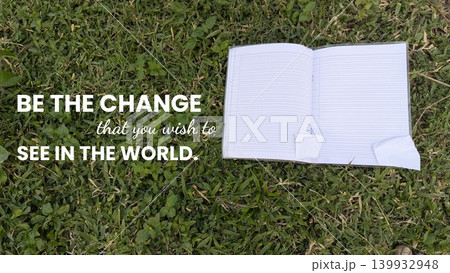 The uplifting quote, BE THE CHANGE you wish to SEE IN THE WORLD, is displayed next to an open book with blank pages lying on a bright green lawn, hinting at a new beginning. The uplifting quote, BE THE CHANGE you wish to SEE IN THE WORLD, is displayed next to an open book with blank pages lying on a bright green lawn, hinting at a new beginning. 139932948