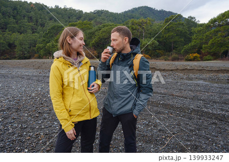 Couple drinks tea by winter sea shore 139933247
