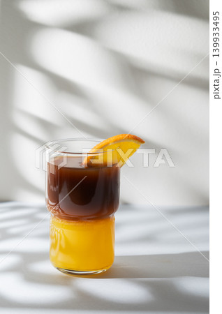 Cold bumble coffee with orange juice and ice on light background 139933495