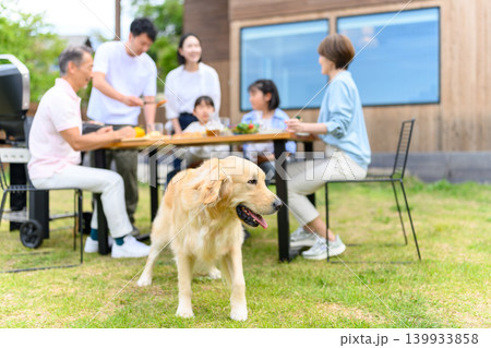 庭でバーベキューを楽しむ家族と犬 139933858