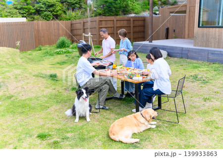 庭でバーベキューを楽しむ家族 139933863