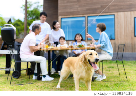 庭でバーベキューを楽しむ家族と犬 庭でバーベキューを楽しむ家族と犬 139934139