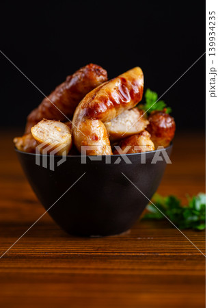 delicious fried sausages with parsley in black bowl delicious fried sausages with parsley in black bowl 139934235