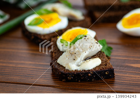 Closeup of herring sandwich on dark rye bread Closeup of herring sandwich on dark rye bread 139934243