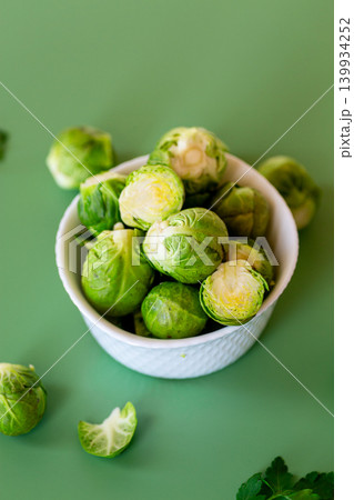 Fresh Brussels sprouts in a white bowl on a green background 139934252