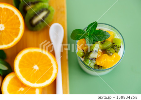 light yogurt snack with fresh kiwi orange and mint leaves 139934258
