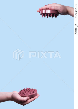 Pink silicone scalp massager in woman hand mockup. Hair brushing and massage. Isolated image for design. Vertical image 139934407