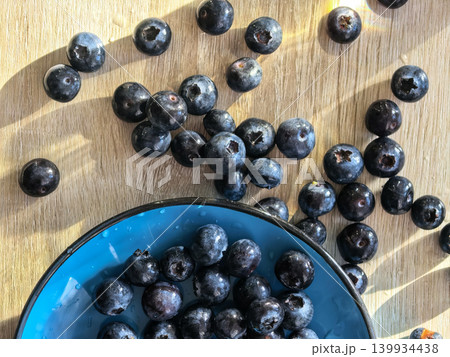 Fresh Blueberries Scattered Near Blue Bowl 139934438