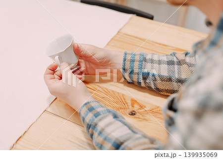 Man holding handmade ceramic cup at painting workshop 139935069