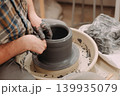 Close-up of a woman's hands shaping a ceramic pot on the lathe 139935079