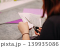 Female hands cutting paper craft at workshop 139935086