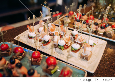 Assorted canapes and finger foods on trays for a holiday buffet 139935087