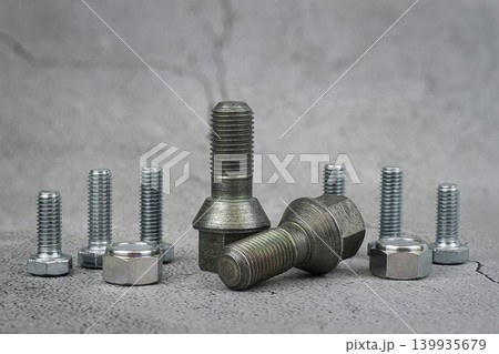 bolts and nuts on a concrete grey background. bolts and nuts on a concrete grey background. 139935679