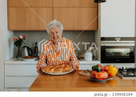 Happy senior woman with homemade easter braided bread with raisins. Close-up. Happy senior woman with homemade easter braided bread with raisins. Close-up. 139936104