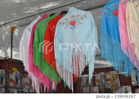 Embroidered fringed shawls in bright colors for feria san isidro madrid market stall display and flamenco costume background 139936167