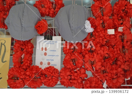 Red carnation accessories and checked hats for san isidro madrid fair stall display and festival decoration Red carnation accessories and checked hats for san isidro madrid fair stall display and festival decoration 139936172