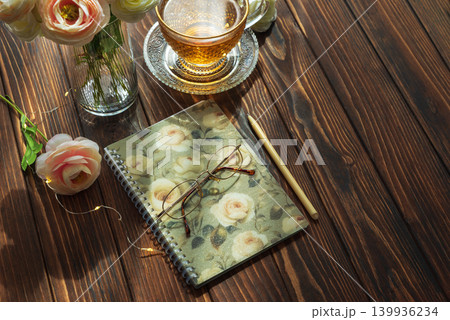Morning tea, closed notebook, and ranunculus creating inspiring for writing Morning tea, closed notebook, and ranunculus creating inspiring for writing 139936234
