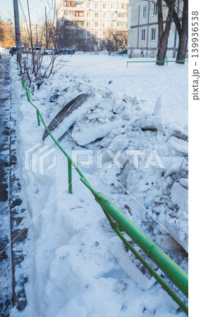 Closeup of large chunks of dirty snow, from a snowplow, on the street. Chunks of dirty snow on the side of the road 139936538