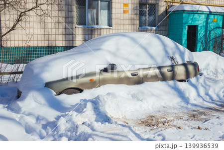 Car in the snow parked near the snow-covered road after a snowfall 139936539