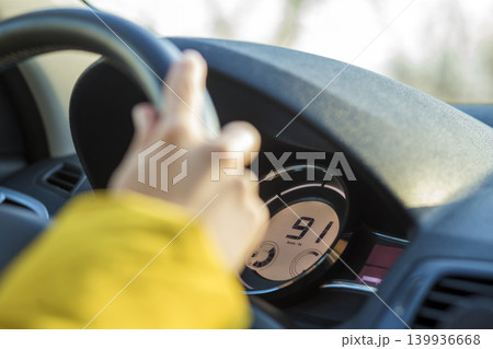 Modern car interior with driver hand on steering wheel. Safe driving concept. 139936668