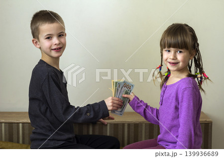 Two little children boy and girl playing with dollars money. Two little children boy and girl playing with dollars money. 139936689