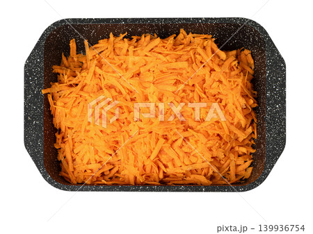 Shredded carrots filling a dark baking tray Shredded carrots filling a dark baking tray 139936754