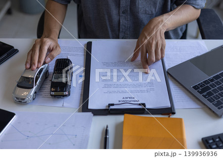 Client Reviewing CarInsurance Policy and Vehicle Finance Documents. Client Reviewing CarInsurance Policy and Vehicle Finance Documents. 139936936