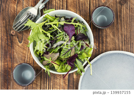 Healthy fresh salad mix of leafy greens on a wooden rustic background. Healthy fresh salad mix of leafy greens on a wooden rustic background. 139937155