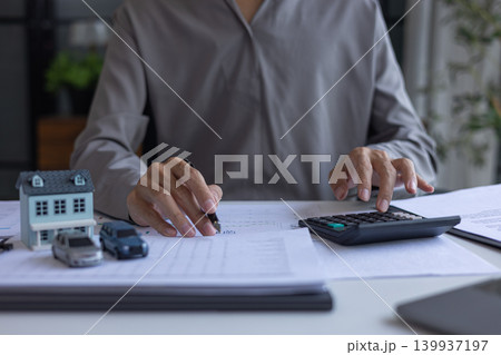 Businessman reviewing financial documents for property investment and auto finance. Businessman reviewing financial documents for property investment and auto finance. 139937197