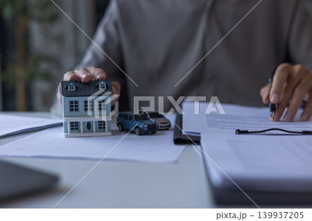 Insurance Advisor Reading Insurance Policy Document on Desk. Bundling Home and Auto Insurance Policy Planning Concept. Insurance Advisor Reading Insurance Policy Document on Desk. Bundling Home and Auto Insurance Policy Planning Concept. 139937205