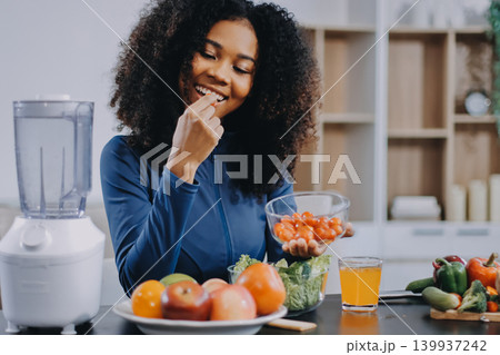 Young nutritionist showing bell peppers during an online video call consulting about healthy eating, sitting at home at a table with vegetables, laptop and measuring tape Young nutritionist showing bell peppers during an online video call consulting about healthy eating, sitting at home at a table with vegetables, laptop and measuring tape 139937242